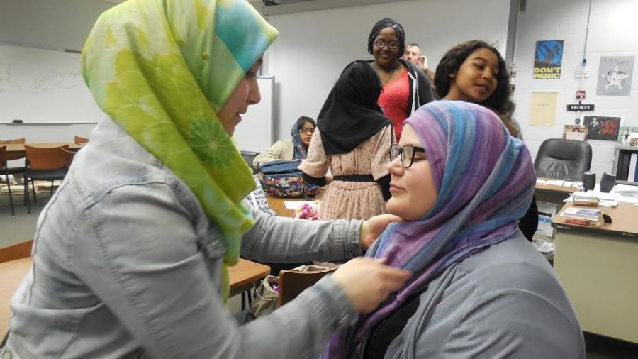 A+member+of+the+Muslim+Student+Association+adjusts+the+headscarf+of+a+participant+in+the+Hijab+Experience+inside+of+Mr.+Troy+Bradburys+classroom%2C+where+participants+met+to+have+their+hijabs+wrapped+on+them%2C+and+where+an+afterschool+discussion+took+place