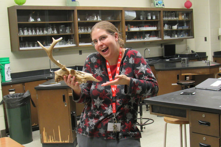 Ms. Komar in her classroom with an animal skull