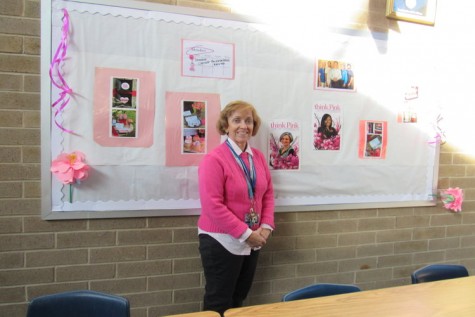 Librarian Ms. Peterson, next to her bulletin board she created 