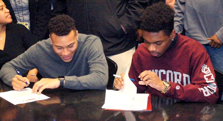 Teyon Davis and RJ Rountree each sign their National Letter of Intent.