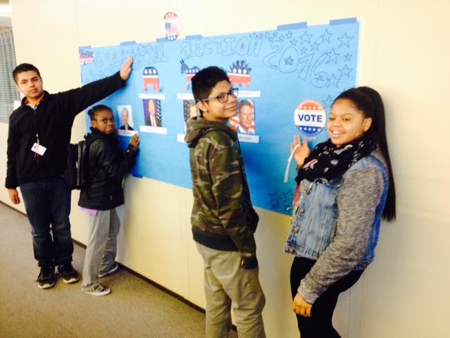 From left to right: Walter Funes, Kierra Tucker, William Flores, and Azahri Rilles help post a bulletin board showing results of the 
2016 Roosevelt mock election.