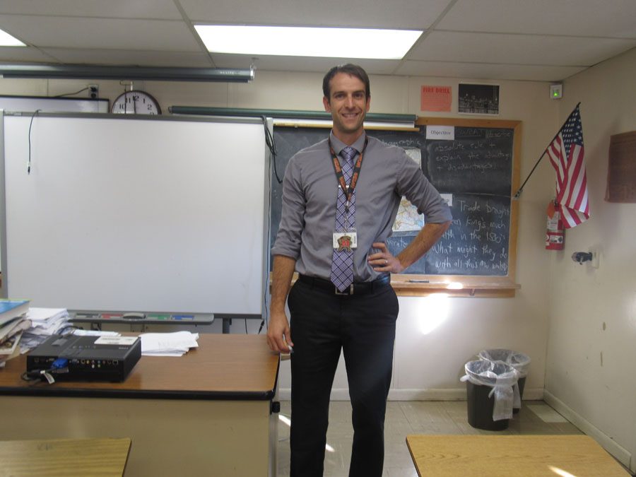 Social studies teacher, Mr. Brendan OConnell, smiling in his classroom. 