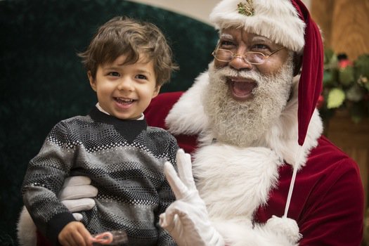 Larry Jefferson, Mall of America's first black Santa, listening to a child's wish list for Christmas. 