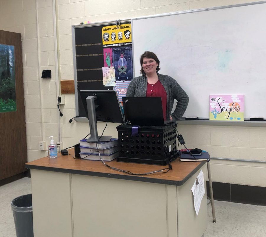 Ms.+Seyler%2C+posing+at+her+desk+in+the+school+building.+Photo+courtesy+of+Ms.+Amie+Littman