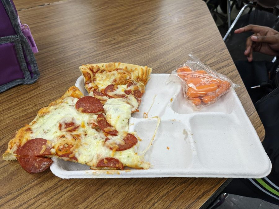A recent school lunch, two slices of pizza with a side side of carrots. Courtesy of Njeri Kamenwa.