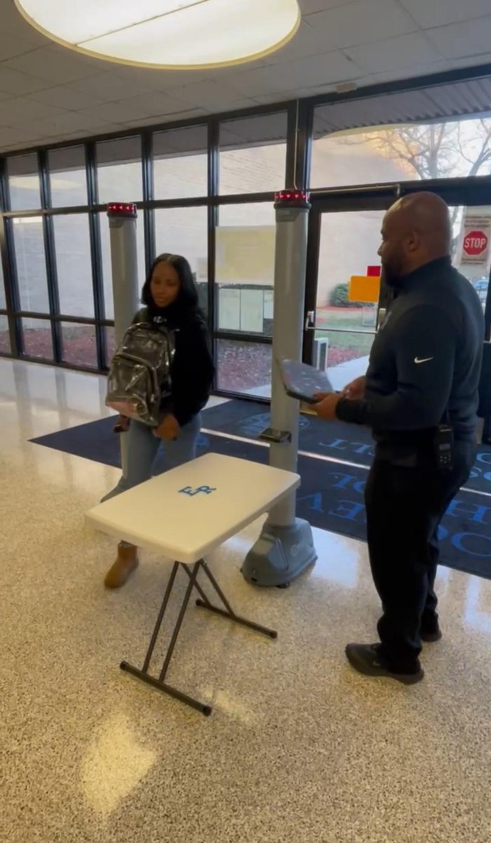 Ms. Jamall demonstrates how to move through the metal detector.