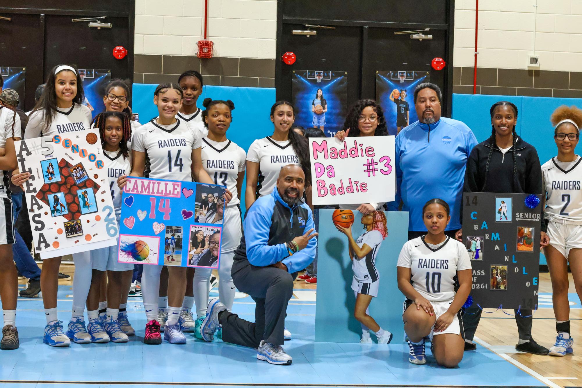 Girls gather for a group photo with coaches. 