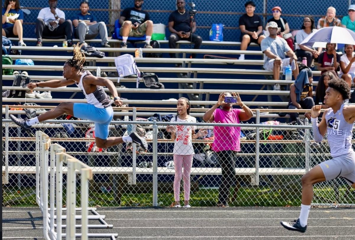 Senior Frank Calhoun leaping over the hurdle