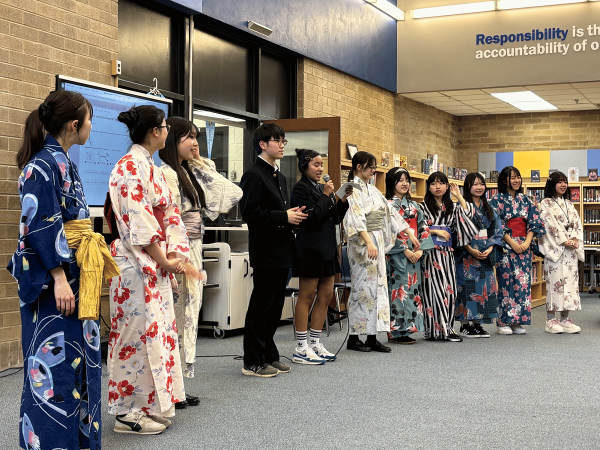 Students from the Kanagawa Board of Education giving a presentation in kimonos, traditional Japanese clothing.